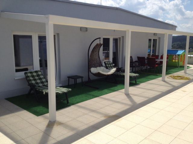 Minimalistická terasa s hliníkovým přístřeškem: méně je více